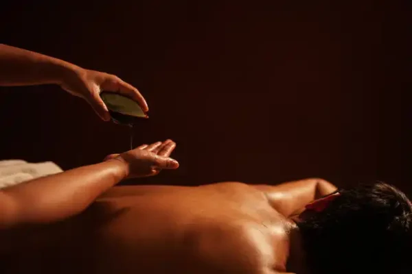 Preparación cuidadosa del aceite por parte del terapeuta para un servicio de masaje Lingam
