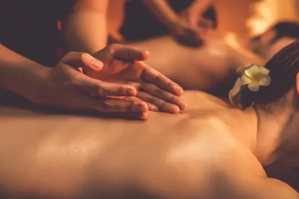 Interlocked hands in a couples massage, symbolizing connection and shared intimacy