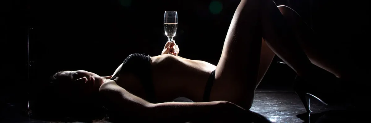 An elegant and relaxed silhouette with a glass of champagne, evoking luxury and pleasure in a Paradise-style massage.