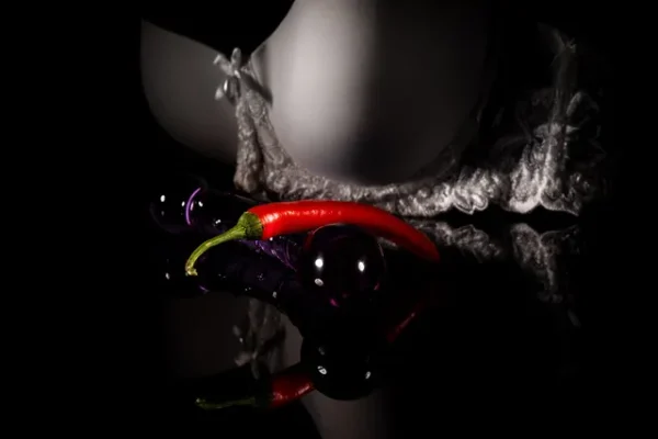 Artistic composition with glass elements and a chili pepper, hinting at a prostate massage experience.