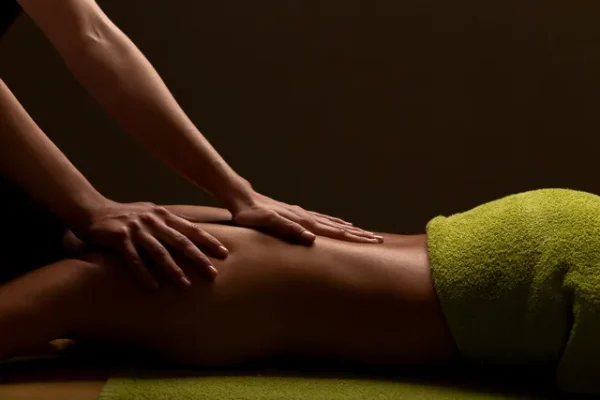Massage technique on legs in a calm and relaxing environment, indicative of a Yoni massage focused on connection and healing.